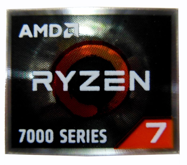 Puede incluir: Una pegatina rectangular con borde plateado. Presenta el logotipo de AMD y la palabra "RYZEN" en blanco. Debajo, se lee "7000 SERIES" y una esquina roja muestra el n&uacute;mero "7". El fondo tiene un patr&oacute;n oscuro y texturizado.