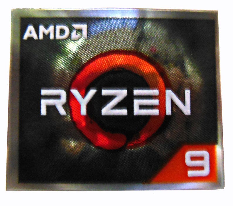 K&ouml;nnte beinhalten: Ein rechteckiger AMD Ryzen 9 Aufkleber. Der Aufkleber zeigt das AMD-Logo in Wei&szlig; oben links. Das Wort "RYZEN" ist wei&szlig;, mit einem roten und orangefarbenen kreisf&ouml;rmigen Design in der Mitte. Die Zahl "9" ist wei&szlig; auf orangefarbenem Hintergrund.