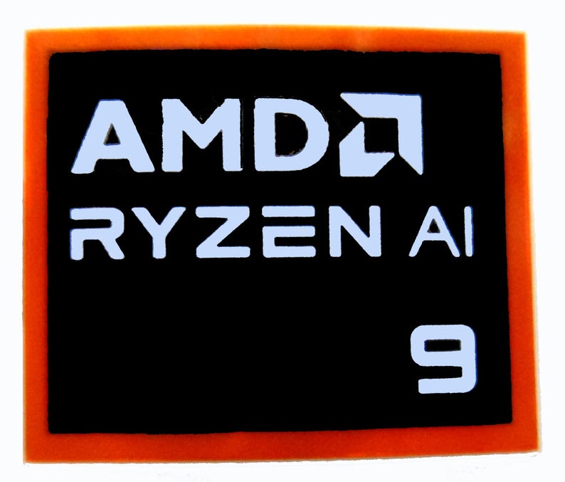 May include: A black rectangular sticker with an orange border. The white text "AMD RYZEN AI 9" is displayed on the sticker, along with the AMD logo. This sticker is likely for a computer component.