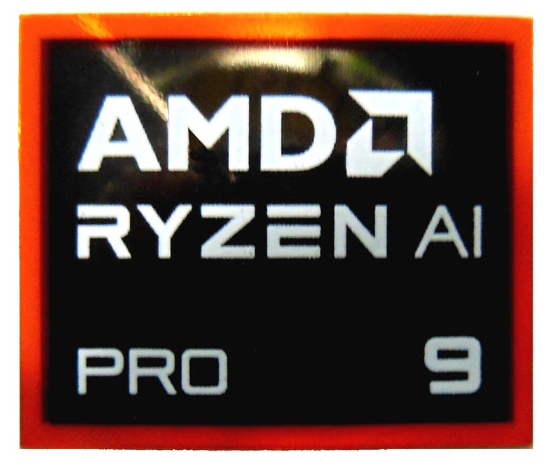 Pu&ograve; includere: Un adesivo rettangolare con sfondo nero e testo bianco. Il testo include "AMD", "RYZEN AI", "PRO" e il numero "9". L'adesivo ha un bordo rosso.