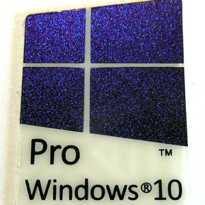 Puede incluir: Una pegatina rectangular con una base blanca y una sección superior azul oscuro texturizada y brillante. La sección superior presenta un diseño de cruz blanca. El texto "Pro Windows® 10" está impreso en negro sobre la base blanca.