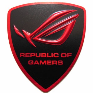May include: A red and black shield-shaped logo with the text "Republic of Gamers" in red letters. The logo features a stylized red wing design.