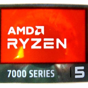 May include: A rectangular sticker with a red background featuring the AMD Ryzen logo in white. Below the logo, the text "7000 SERIES" and the number "5" are displayed in white on a gray textured background. The sticker has a black border.