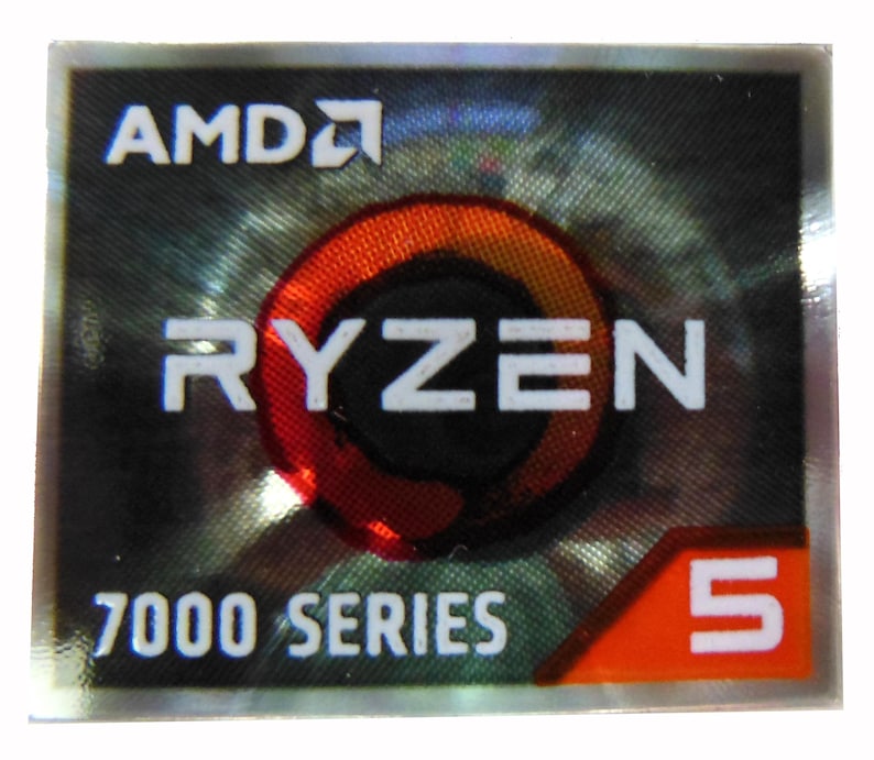 Puede incluir: Una pegatina rectangular con el logotipo de AMD y la palabra "RYZEN" en blanco. La pegatina tambi&eacute;n presenta el texto "7000 SERIES" y el n&uacute;mero "5" en un cuadro naranja. El fondo tiene un patr&oacute;n oscuro y reflectante.