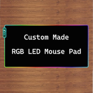 May include: Black mouse mat with a rainbow border and the text "Custom Made RGB LED Mouse Pad" in white.