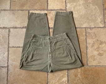 May include: A pair of olive green high-waisted pants with pleats and a button closure.
