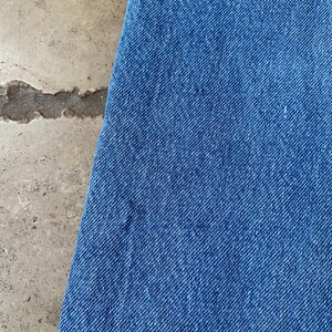 K&ouml;nnte beinhalten: Nahaufnahme eines blauen Jeansstoffes mit diagonalem Webmuster.