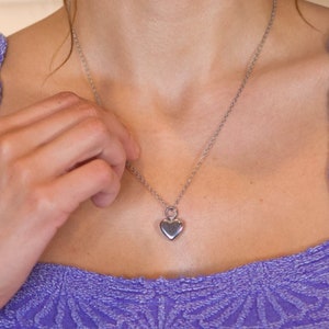 May include: A silver chain necklace with a heart pendant.