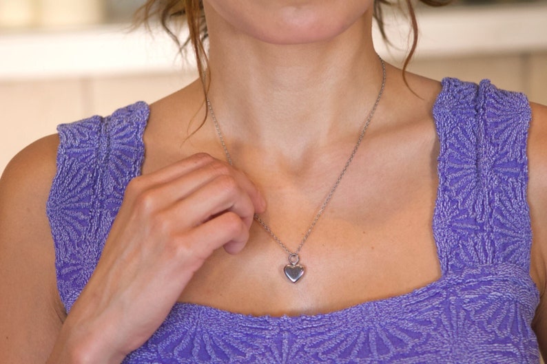 May include: A silver chain necklace with a heart pendant.