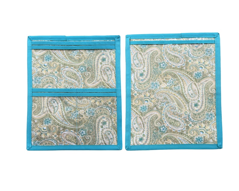 Pu&ograve; includere: Due presine rettangolari in tessuto con motivo paisley nei toni del verde salvia, beige e azzurro. Ogni articolo &egrave; rifinito con un bordo in tessuto blu turchese brillante lungo i lati e include un dettaglio a tasca orizzontale.