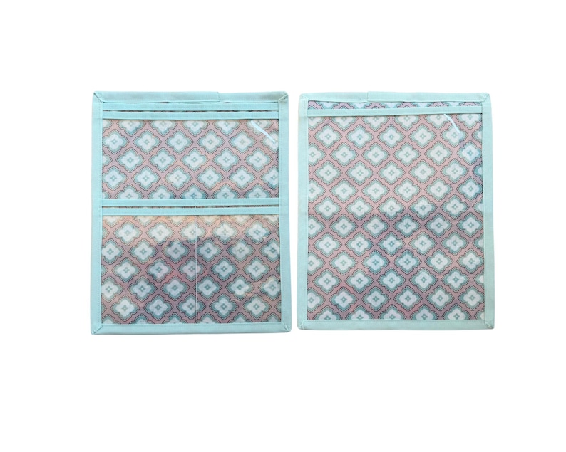 Pu&ograve; includere: Due organizer rettangolari in tessuto con bordo azzurro e un motivo geometrico ripetuto nei toni dell'azzurro, bianco e rosa corallo. Un organizer presenta due tasche orizzontali, mentre l'altro ha un design a tasca singola.