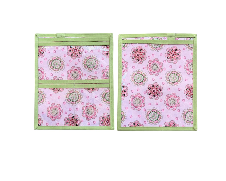 Pu&ograve; includere: Due organizer in tessuto rettangolari con uno sfondo rosa chiaro caratterizzato da un motivo floreale ripetuto nelle tonalit&agrave; del rosa, verde e bianco. Gli organizer sono rifiniti con bordi in tessuto verde chiaro e includono tasche orizzontali.