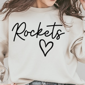 May include: A white sweatshirt with the word "Rockets" written in black cursive script with a black heart underneath.