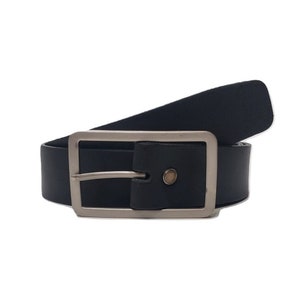 Peut inclure: Une ceinture en cuir noir avec une boucle argent&eacute;e. La ceinture est pli&eacute;e en deux et la boucle est visible.