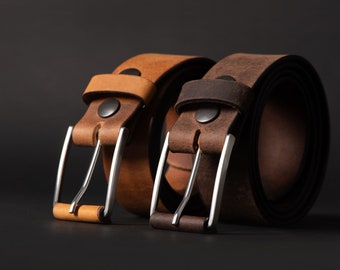May include: Two leather belts with silver buckles. One belt is brown and the other is tan.