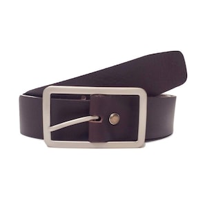 Peut inclure: Une ceinture en cuir marron avec une boucle argent&eacute;e. La ceinture est pli&eacute;e en deux et la boucle est visible au centre de l'image.