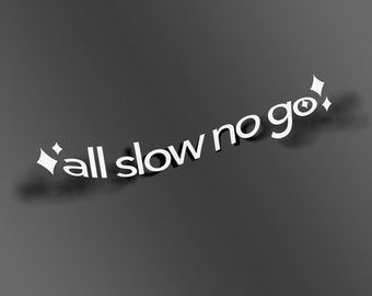 Pode incluir: Um autocolante de vinil branco com o texto "all slow no go" numa fonte sem serifa em minúsculas, disposto numa ligeira curva ascendente. O design é acentuado por dois ícones de estrelas de quatro pontas nas extremidades.