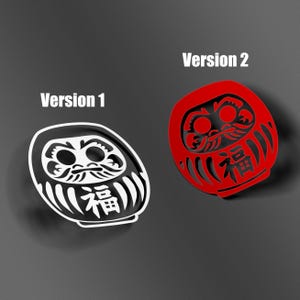 May include: Two Daruma doll stickers. Version 1 is black and white, with the Japanese character for "fortune." Version 2 is red with the same character. Both have a rounded shape and stylized facial features.
