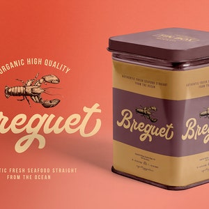 May include: A brown metal tin with a gold label. The label has the text "Breguet" in a stylized font and a drawing of a lobster. The text "Authentic Fresh Seafood Straight From The Ocean" is also on the label.