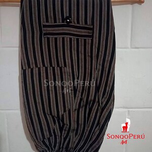 May include: Black and white striped pants with a brown stripe. The pants have two pockets and a button on the front. The pants are made of a soft, comfortable fabric. The pants are labeled "Sonqo Peru Art".