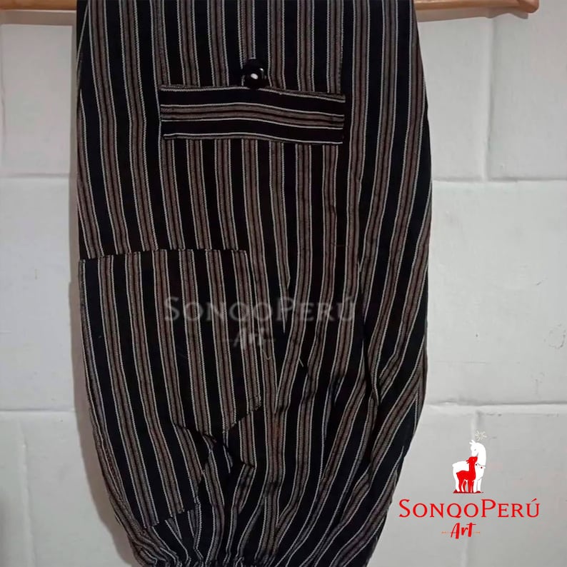 May include: Black and white striped pants with a brown stripe. The pants have two pockets and a button on the front. The pants are made of a soft, comfortable fabric. The pants are labeled "Sonqo Peru Art".