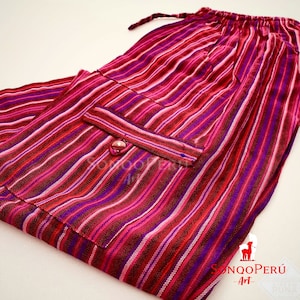 May include: Striped pants with a pink, red, and purple color scheme. The pants have a drawstring waist and a single pocket on the front. The pants are made of a soft, woven fabric.