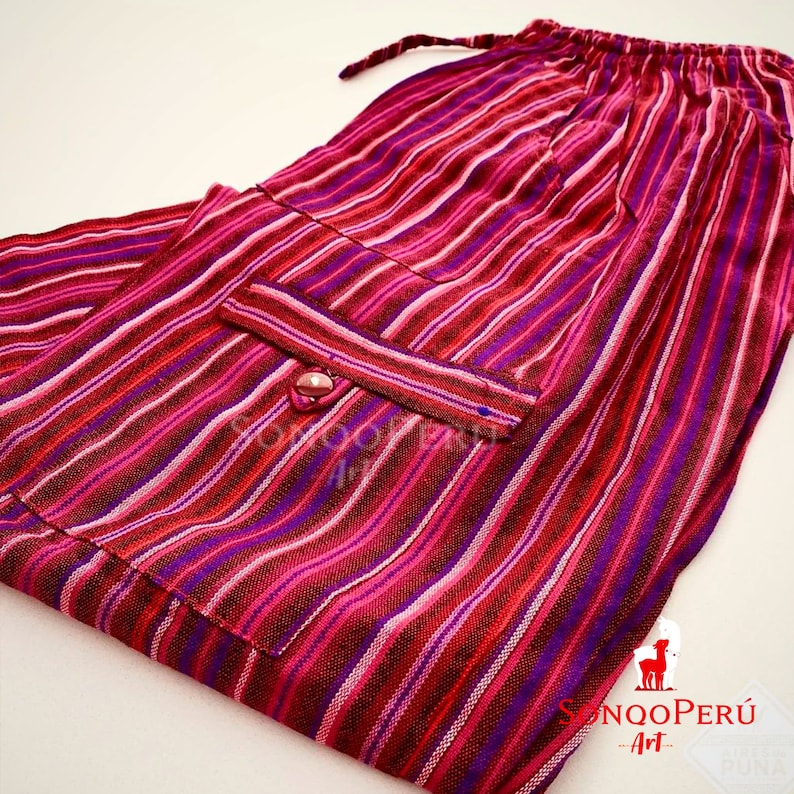 May include: Striped pants with a pink, red, and purple color scheme. The pants have a drawstring waist and a single pocket on the front. The pants are made of a soft, woven fabric.
