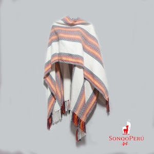 Può includere: Poncho bianco con strisce arancioni, rosse e grigie. Il poncho ha frange sul fondo ed è realizzato in un tessuto morbido e tessuto.