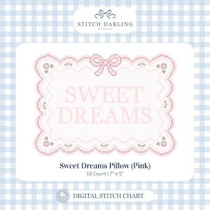 May include: A digital cross stitch pattern titled Sweet Dreams Pillow (Pink) featuring the text SWEET DREAMS in a scalloped pink frame with a bow and floral accents. The chart is for 18 count fabric and measures 7 inches by 5 inches.