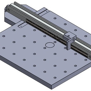 Könnte beinhalten: Eine graue Metallplattform mit einem Lochraster und einem linearen Gleitschienen-System. Die Gleitschiene ist auf der Plattform montiert und kann sich entlang der Länge der Plattform bewegen.