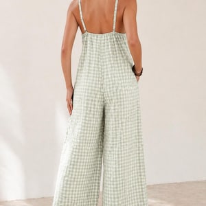 May include: A light green and white gingham jumpsuit with wide legs and thin straps. The backless design features a gathered bodice and pockets. The casual one-piece outfit is suitable for warm weather.
