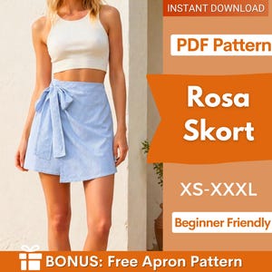 Op de afbeelding: Een vrouw draagt een witte crop top en een lichtblauwe wikkelrok met verticale strepen. De rok heeft een strikdetail in de taille. De afbeelding bevat ook de tekst "Rosa Skort" en "PDF Pattern".