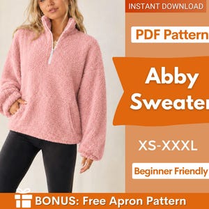 May include: A pink long-sleeve pullover sweater with a high collar and a white front zip. The text on the image reads PDF Pattern, Abby Sweater, XS-XXXL, Beginner Friendly, and BONUS: Free Apron Pattern. The sweater has a textured fleece finish.