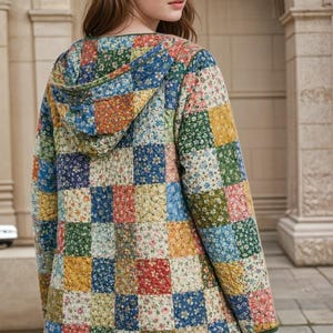May include: A quilted jacket with a patchwork design. The jacket features a hood and is composed of squares in various colors, including blue, red, yellow, and green, each with a floral pattern. The jacket has a green trim.
