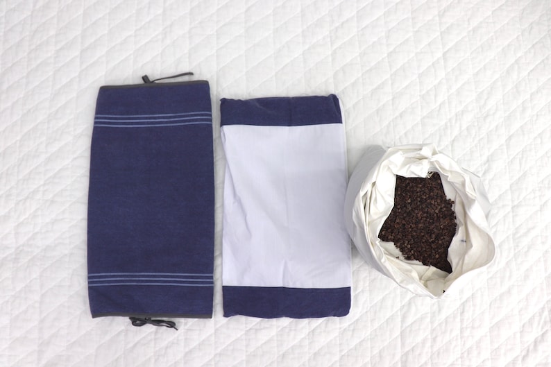 May include: Three pillowcases, one blue with white stripes, one white with a blue border, and one white with buckwheat hulls inside.