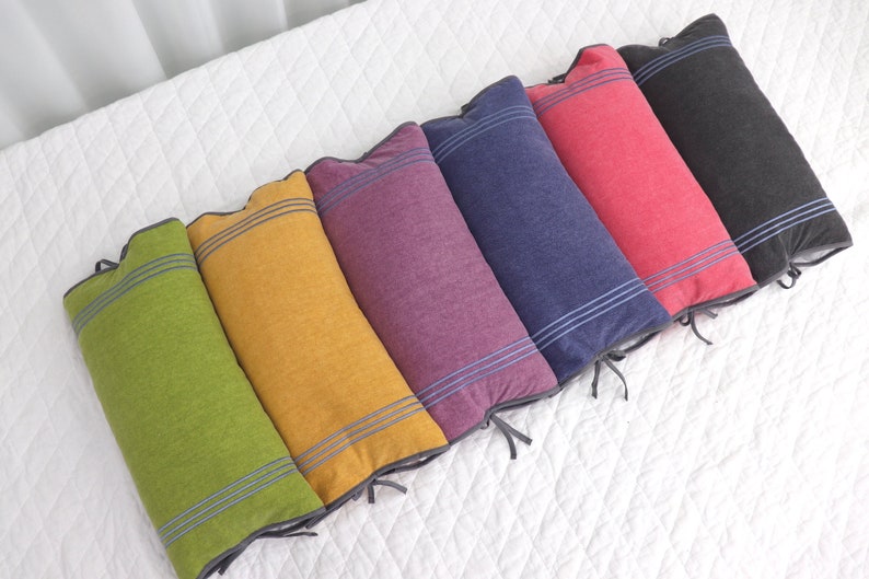 May include: Six decorative pillows in various colors, including green, yellow, purple, blue, red, and gray. Each pillow has a striped pattern with a dark gray border.