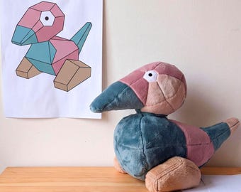 May include: A plush toy shaped like a geometric bird with a pink head, teal beak and body, and tan feet. The toy features a white eye with a black pupil. A matching geometric drawing of the bird is displayed on the wall behind the plush figure.