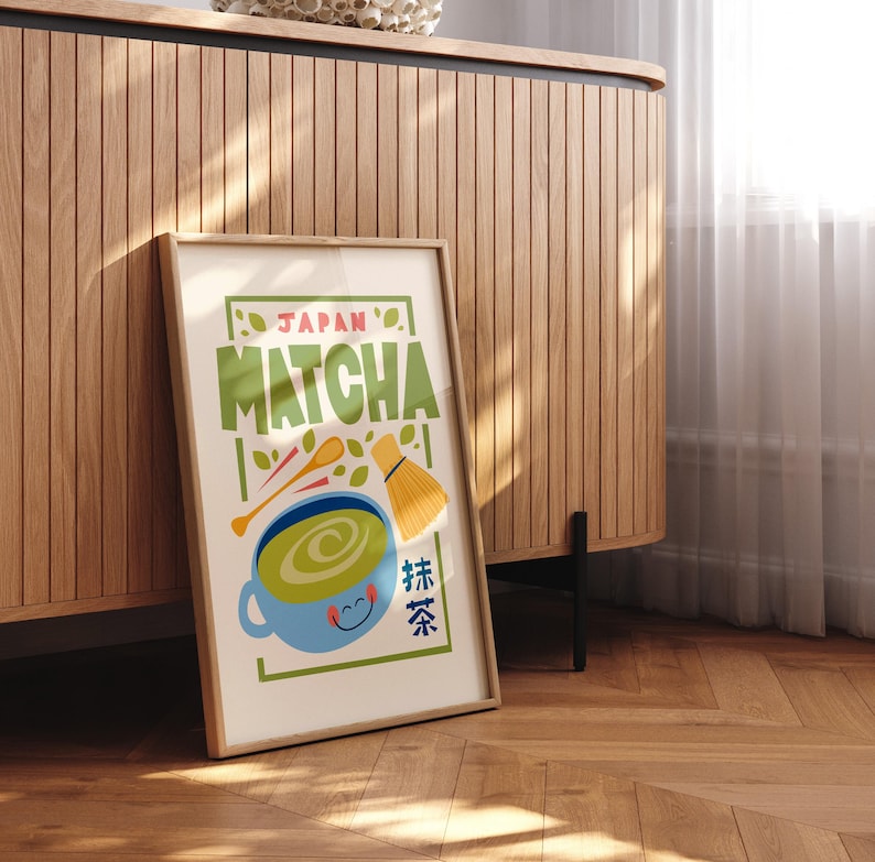 May include: A framed poster with a colorful illustration of a cup of matcha green tea. The poster has the text "JAPAN MATCHA" and Japanese characters for "matcha" in green, yellow, and red.