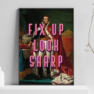 Puede incluir: Impresión artística enmarcada con un retrato clásico de un hombre con vestimenta real. El texto rosa brillante "FIX UP LOOK SHARP" está superpuesto. La obra de arte se exhibe en un estante blanco con decoración minimalista.