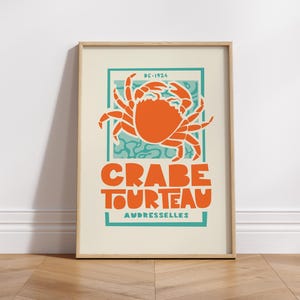 Op de afbeelding: Een vintage poster met een turquoise en oranje kleurenschema met een krabillustratie en de tekst "CRABE TOURTEAU AUDRESSELLE"