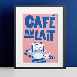 Almanac Co Prints framed 'Café au Lait' poster with bold blue text and a cheerful character, set against a pink background for fun kitchen decor. Framed against a navy wall.