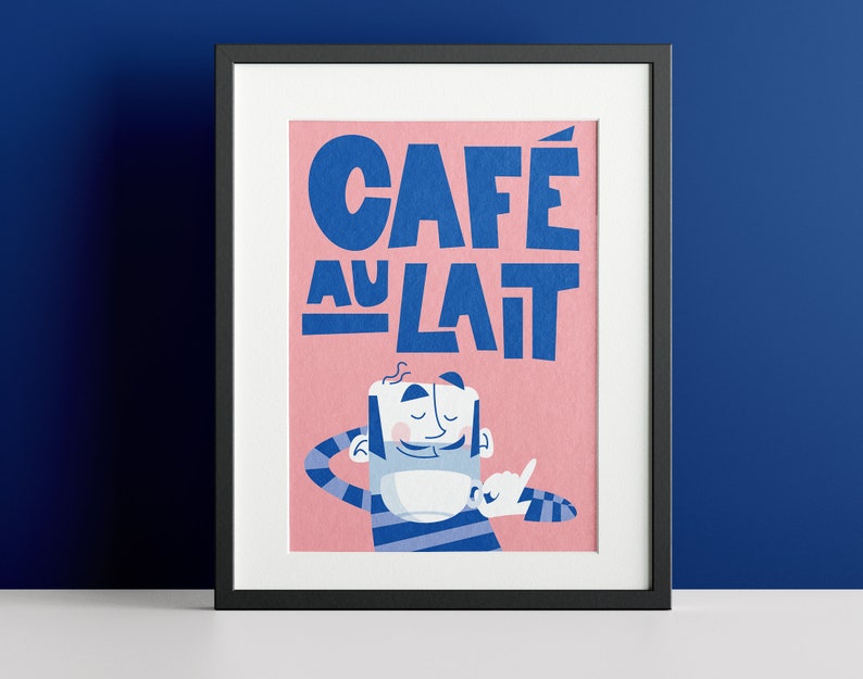 Almanac Co Prints framed 'Café au Lait' poster with bold blue text and a cheerful character, set against a pink background for fun kitchen decor. Framed against a navy wall.