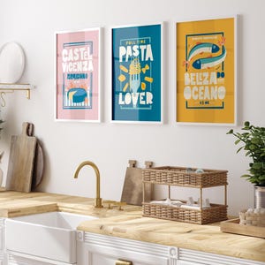 Three framed Almanac Co Prints on a wall, featuring vibrant, retro-style designs of cheese, pasta, and fish illustrations.