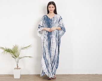 Puede incluir: Un vestido largo y fluido de kaftán de color blanco y azul con estampado tie-dye, cuello en V y mangas 3/4.