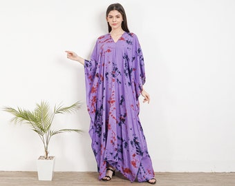 Może przedstawiać: Długa, fioletowa kaftan z wzorem tie-dye w odcieniach niebieskiego i czerwonego. Kaftan ma dekolt w kształcie litery V i długie rękawy.
