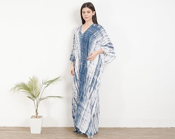 Puede incluir: Un vestido largo de kaftán de color blanco y azul con estampado tie-dye, cuello en V y mangas 3/4.