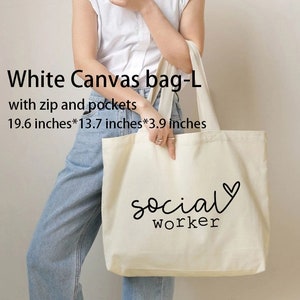 May include: White canvas tote bag with a black zipper and pockets. The bag is 19.6 inches by 13.7 inches by 3.9 inches and has the text "social worker" with a heart printed on it.