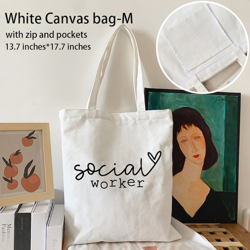 May include: White canvas tote bag with a zipper and pockets. The bag is 13.7 inches by 17.7 inches and has the text "social worker" with a heart printed on it.