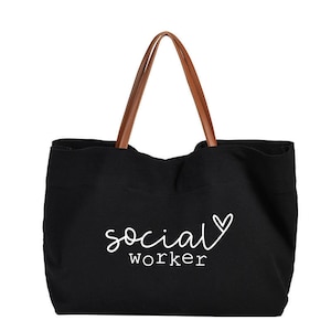 May include: Black canvas tote bag with brown leather handles. The bag has white text that says "social worker" with a heart symbol.