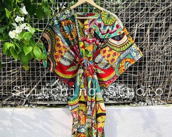 May include: A brightly coloured patterned caftan dress with a V-neck and wide sleeves. The dress features a vibrant mix of red, yellow, green, and blue patterns. The text "Stitching Studio" is visible at the bottom of the image.